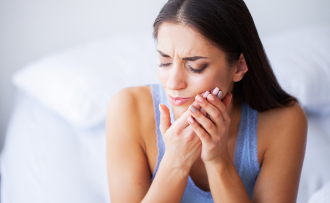 Woman wincing from jaw pain